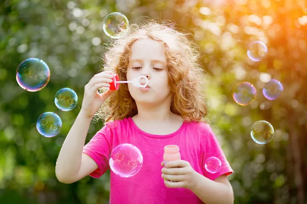 Girl blowing soap bubbles,  toning for instagram filter.