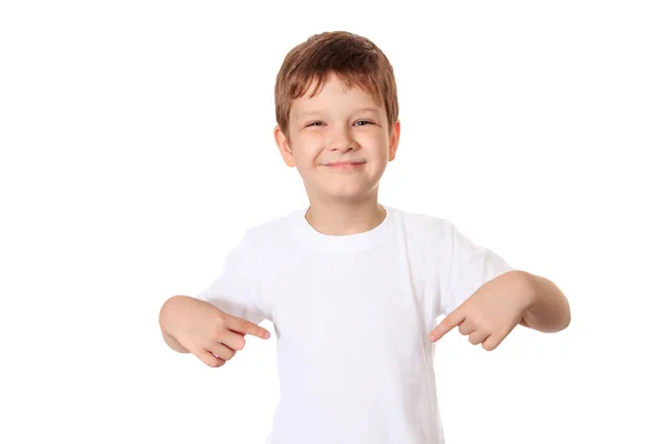 Happy little boy pointing his fingers on a blank t-shirt, a plac