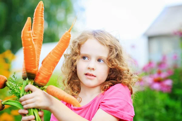 Cute little girl with yellow carrot.