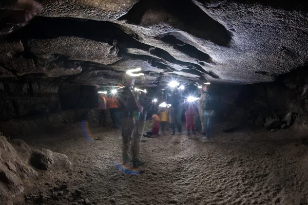 People exploring dark cave