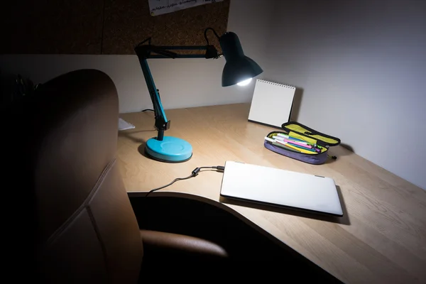 Home or office desk with lamp and laptop