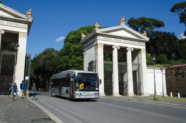 Bus at a street with old gate in Rome, Italy