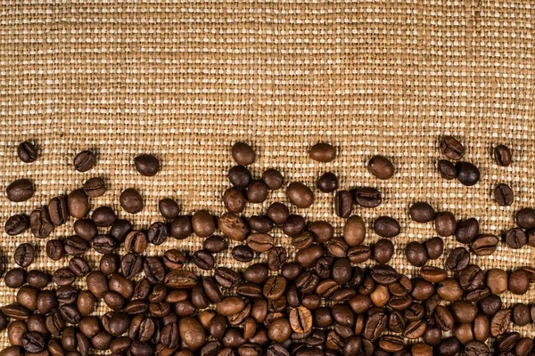 Coffee beans scattered on burlap can be used as background