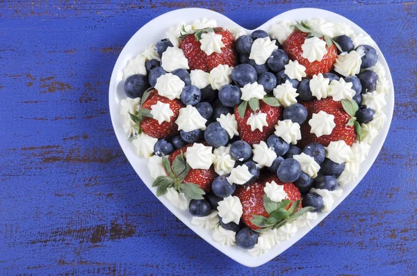 Red white and blue berries with fresh whipped cream stars.