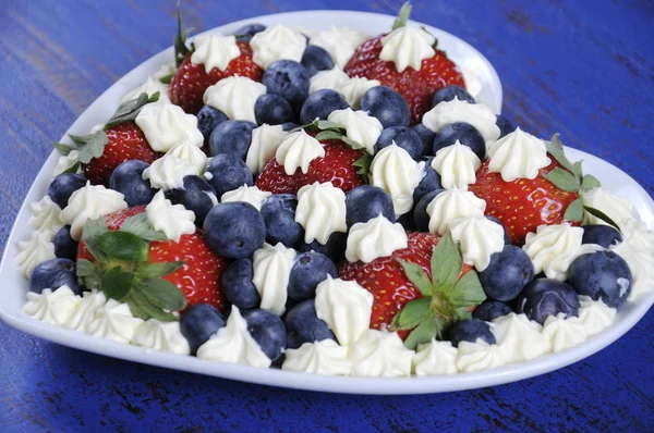 Red white and blue berries with fresh whipped cream stars.