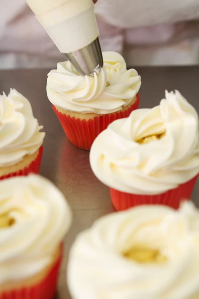 Whipped butter cream frosting applied to cupcakes