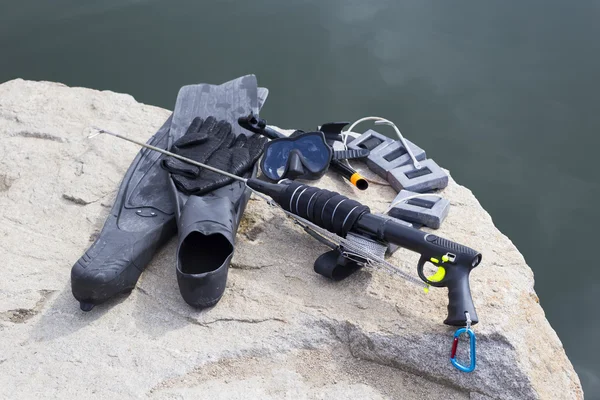 Equipment underwater hunter rests on a rock.diving equipment