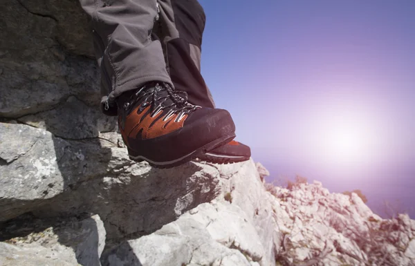 A traveler stands on top of a mountain and looks out to sea.