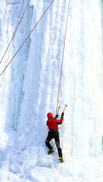 Man climbing frozen waterfall.