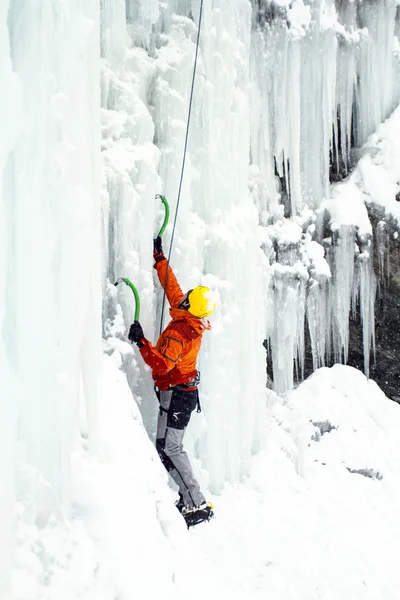 Man climbing frozen waterfall.