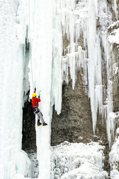 Man climbing frozen waterfall.