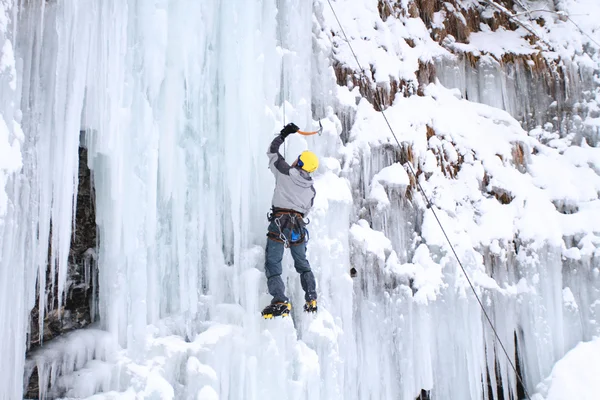 Man climbing frozen waterfall