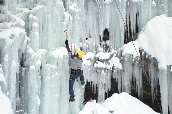 Man climbing frozen waterfall