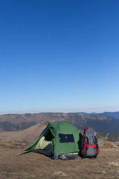 Solar panel.The solar panel attached to the tent. The man sitting next to mobile phone charges from the sun.