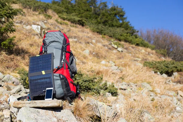 Solar panel.The solar panel attached to the tent. The man sitting next to mobile phone charges from the sun.