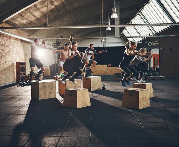Fit people doing box jumps