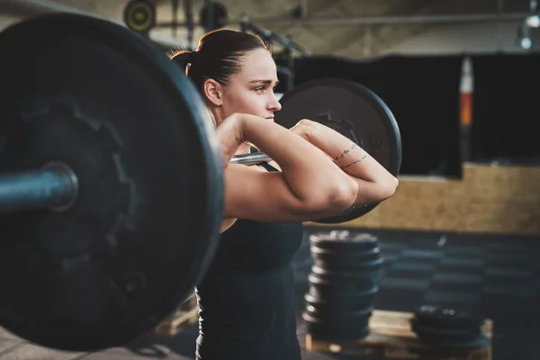 Fit young woman lifting barbells