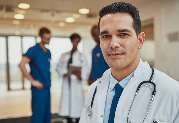 Male doctor with colleagues in background