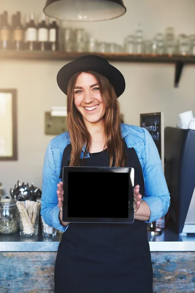 Female entrepreneur wearing black hat and apron