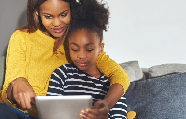 Black mom and daughter learning on tablet