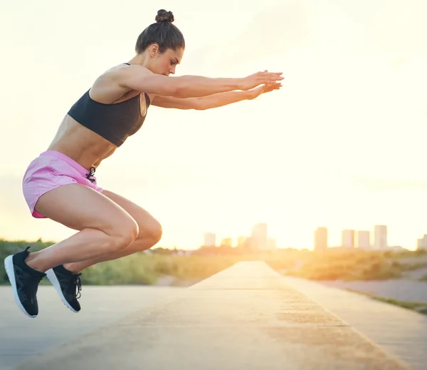 Young woman doing crossfit exercises outdoors