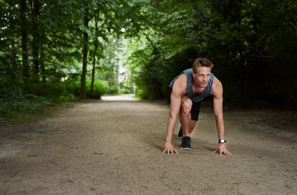 Athletic Man in Running Start Position at the Park