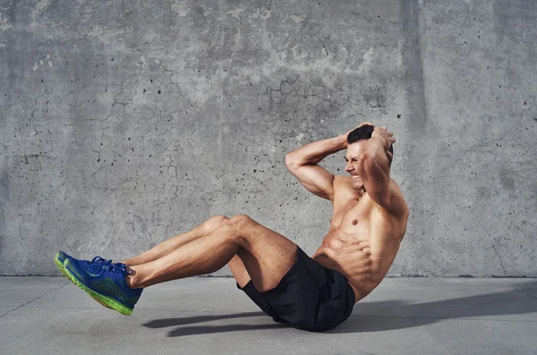 Fitness model exercising sit ups