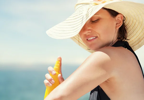 Woman apply suntan lotion