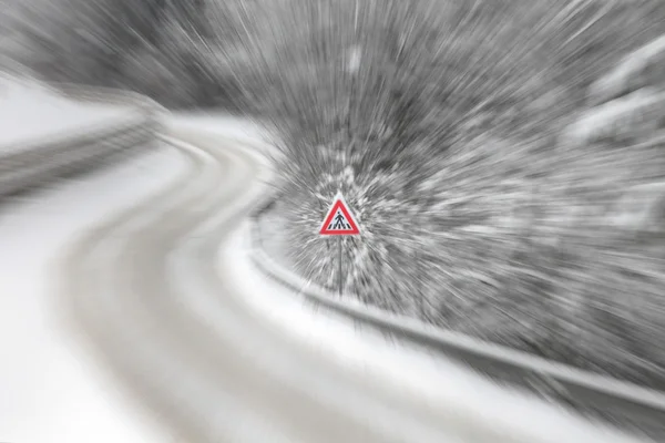 Pedestrian warning sign on a snowy road