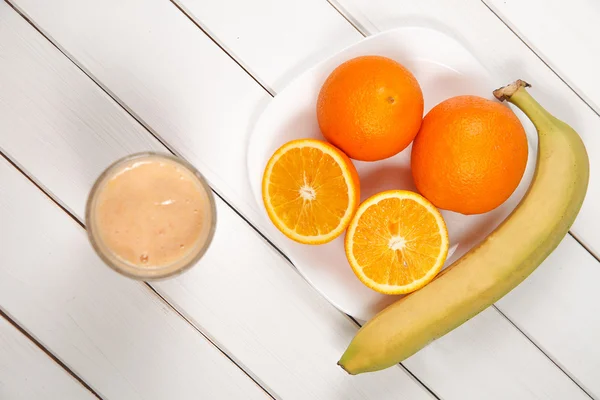 Healthy drink orange and banana smoothies on wooden table