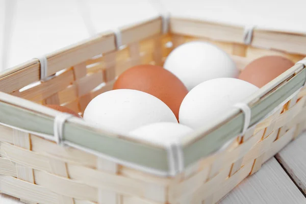 Eggs in a wooden basket on the table from the old boards