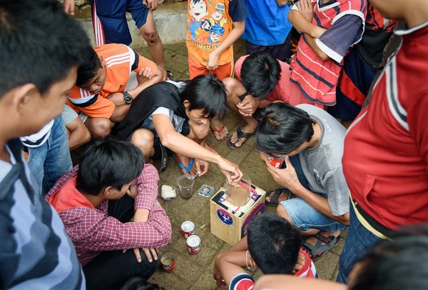 Indonesian boys spend the cricket fighting in the street
