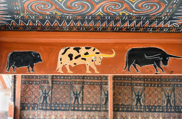 Toraja traditional house wood carvings and paitings with different buffaloes and pig