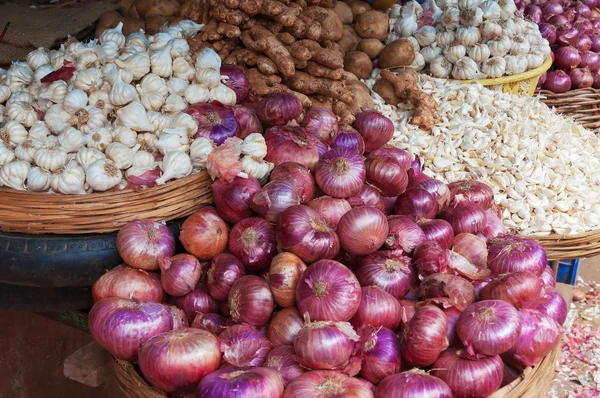 Pile of fresh red onions, garlic, ginger, potato on the market