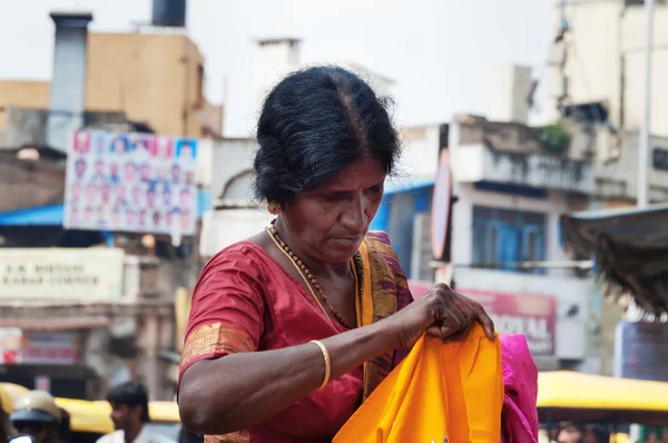 Indian woman chooses clothes at the Russell market in Bangalore