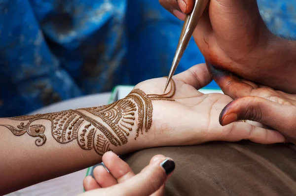 Painting Henna paste on woman's hand