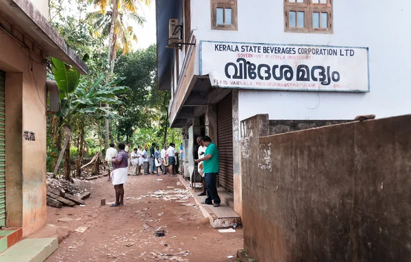 People stand in a queue to alcoholic shop. Varkala