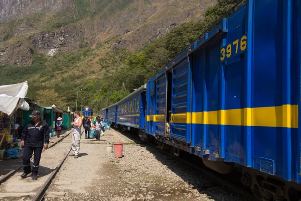 People and baggages on railway track to Machu Picchu, Peru