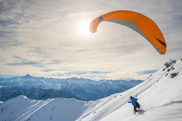 Paraglider launching from snowy slope