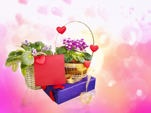The basket with violets decor with hearts and ribbon