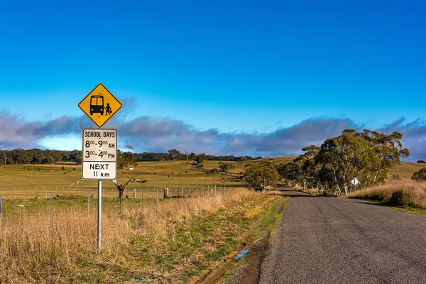 Australian outback road with school bus stop sign