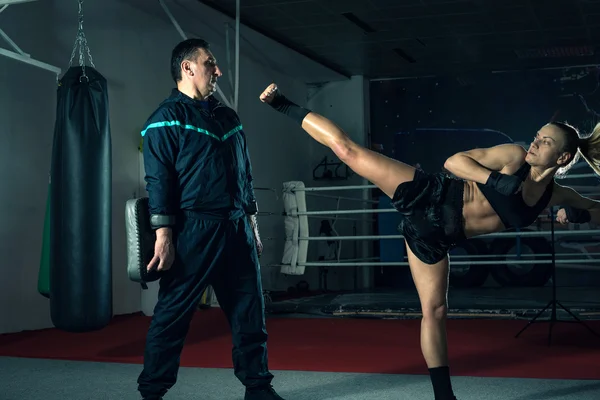 Girl kicking back leg during kickboxing practice