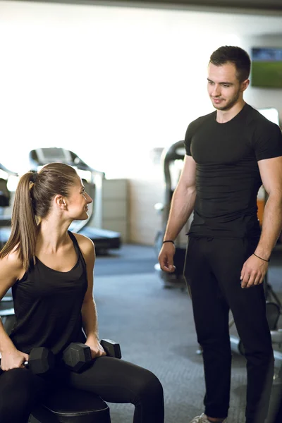 Personal trainer talks to his client.