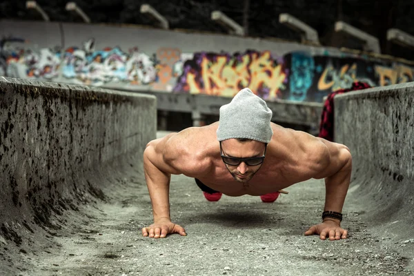 Slim fit man doing outdoor push ups