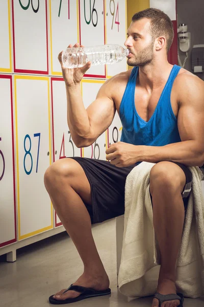 Man drinking water in locker room