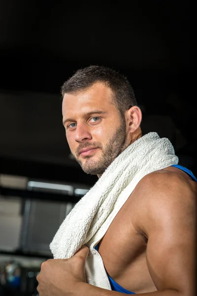 Man in gym with towel around neck