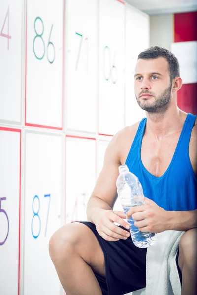 Man drinking water in locker room