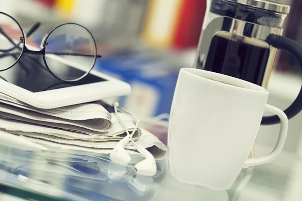 Cup of coffee and newspaper on table