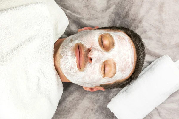 Man laying with cream mask