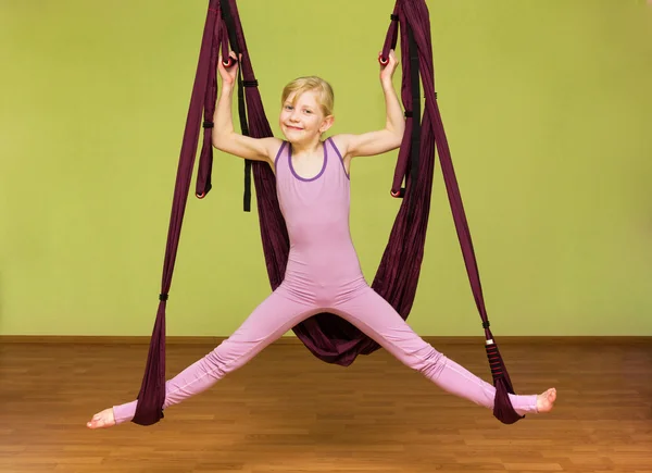 Little girl making aerial yoga exercises, indoor